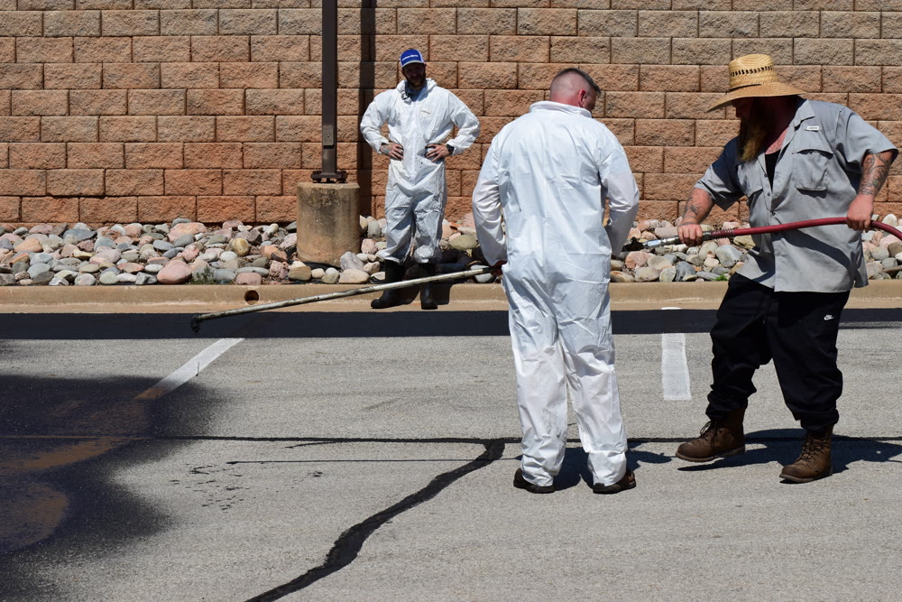 Crew in full PPE prepping pavement for hot rubber crack sealing